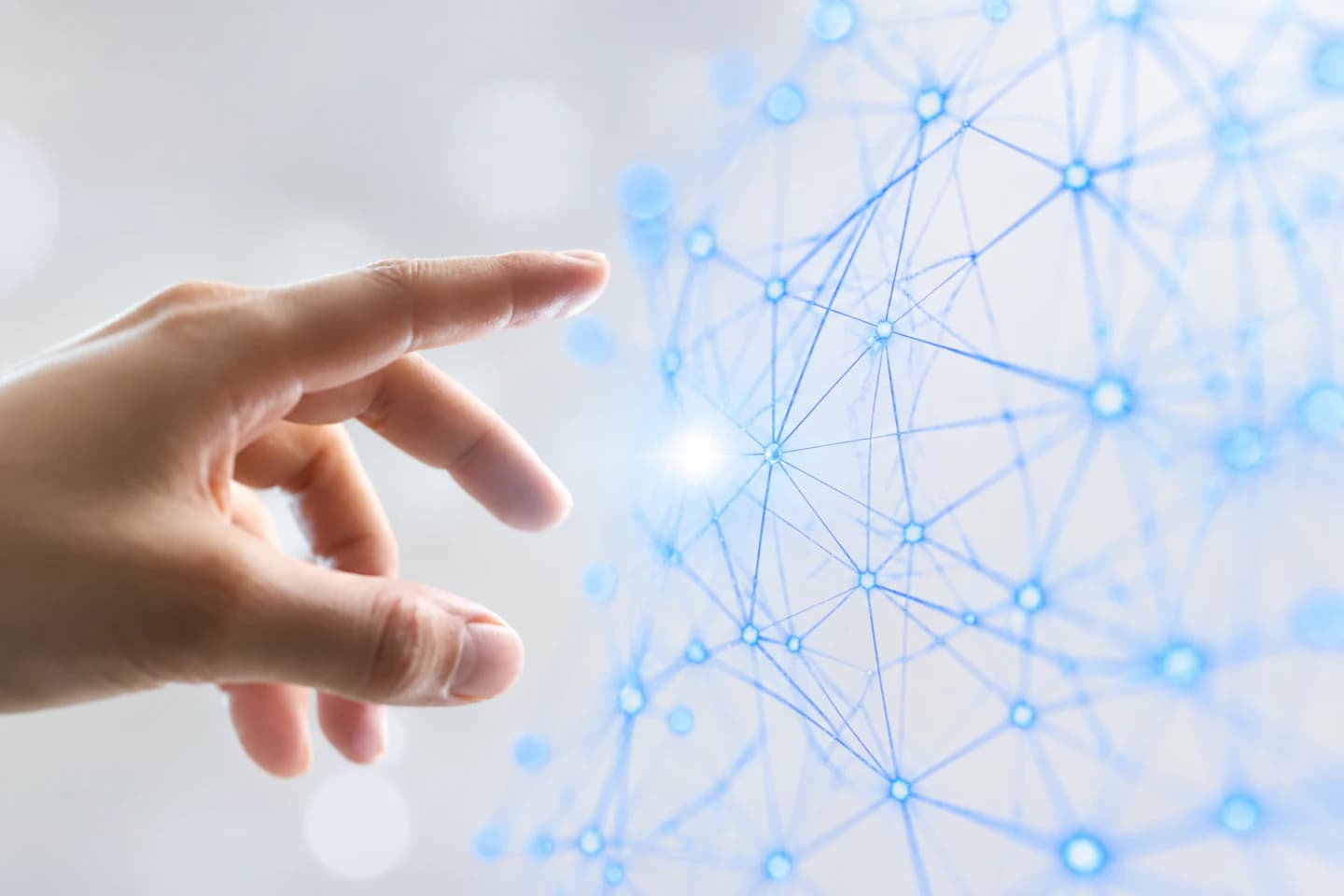 A human hand reaching toward a glowing blue AI neural network visualization